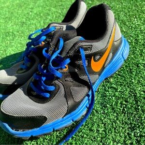 Blue, black, and orange training Nike shoes.
There is some damage to one shoe.
